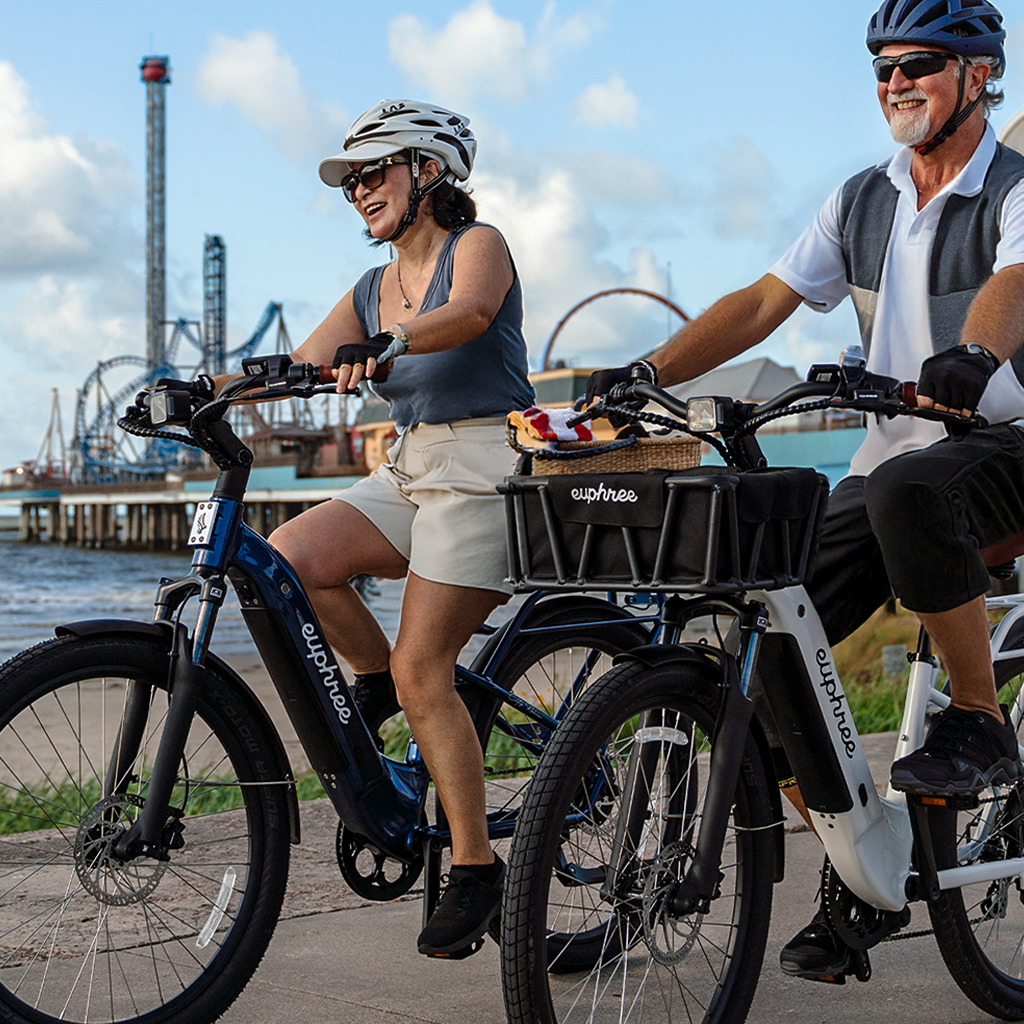 Couple riding Euphree City Robin X+ electric bikes along a beach path